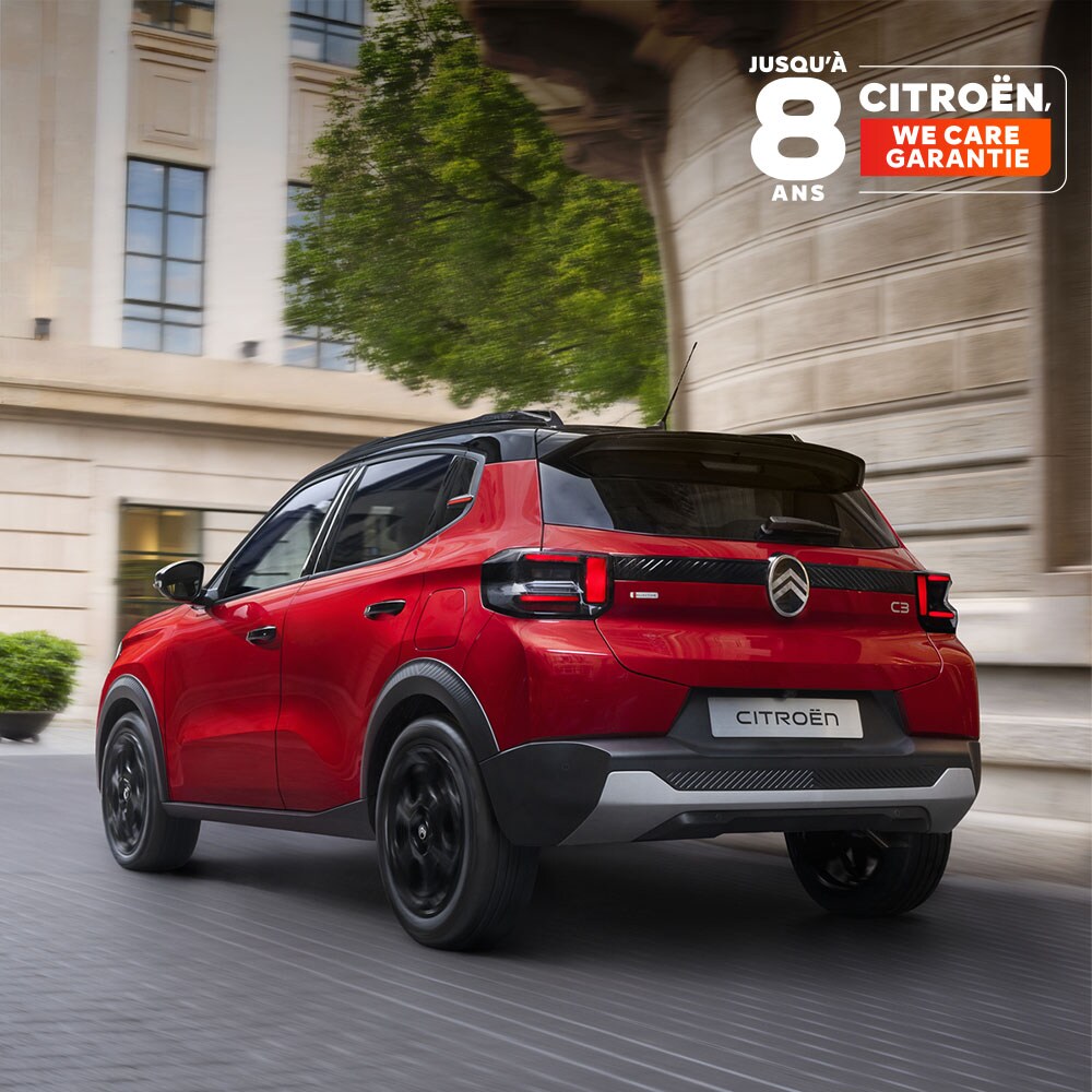 Vue arrière trois-quarts de conduite du SUV compact Citroën C3 mettant en avant ses performances urbaines fluides et sa garantie de 8 ans pour une mobilité sereine et abordable.