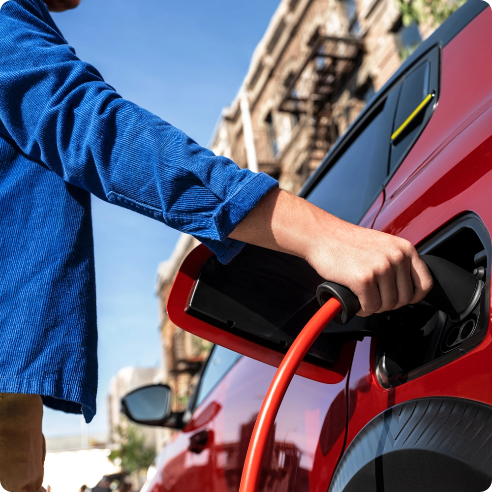 Gros plan sur le port de recharge de la Citroën ë-C3 Van branché à un câble de recharge, mettant en avant la facilité de recharge électrique et la mobilité zéro émission.