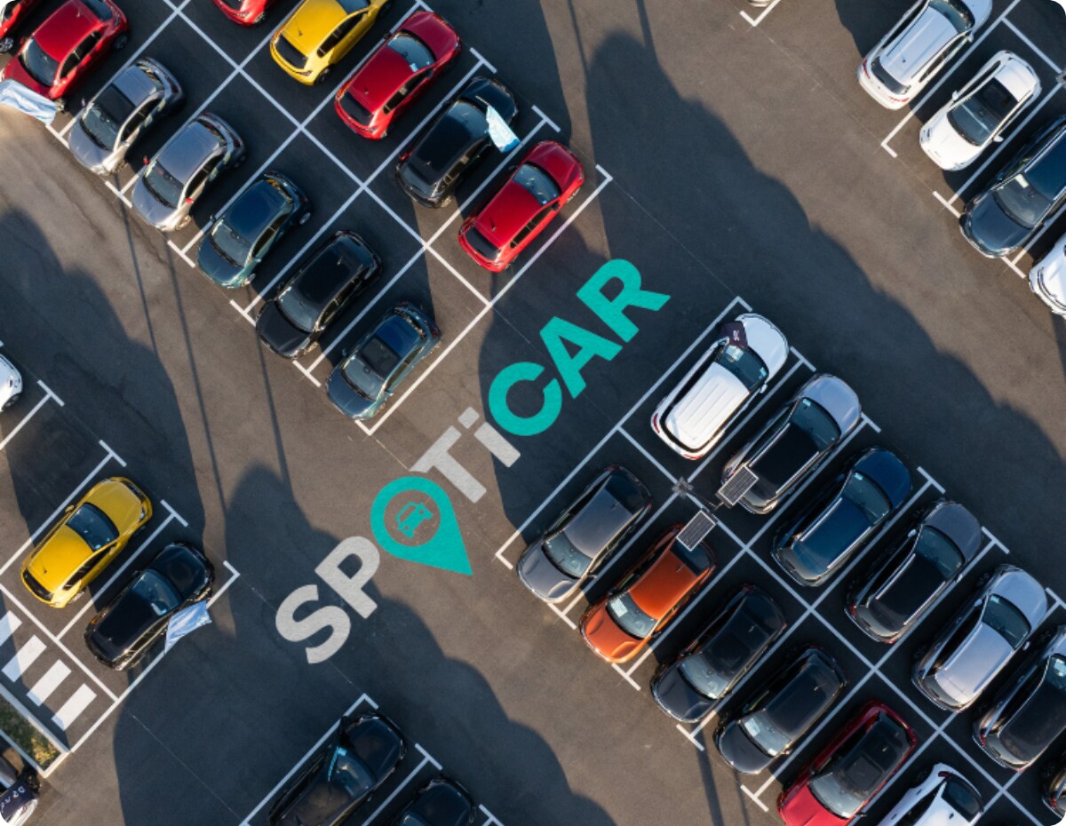 Vue aérienne d’un parking avec plusieurs véhicules et le logo Spoticar, mettant en avant les véhicules d’occasion certifiés Citroën et leur disponibilité.