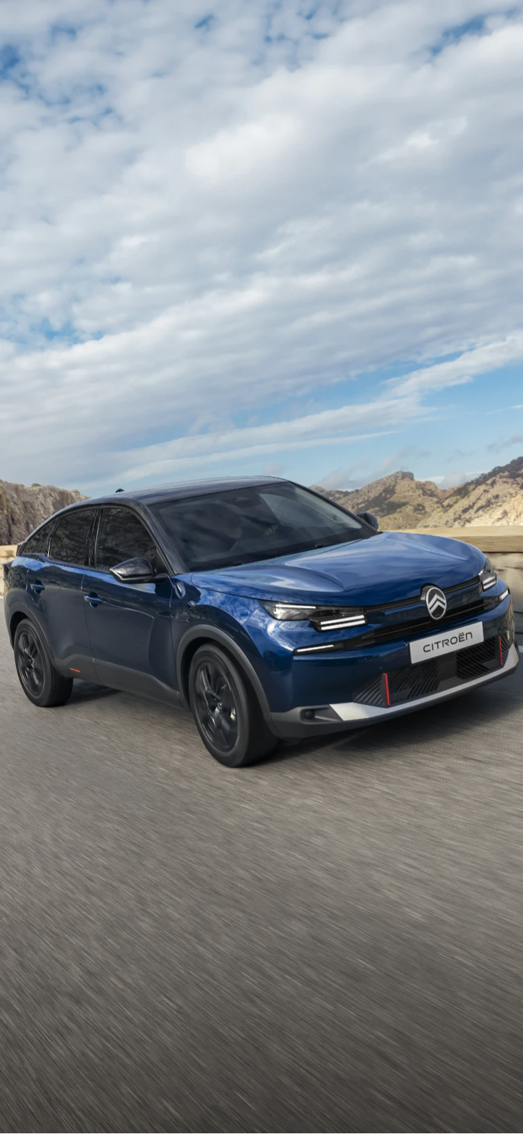 Vue de trois quarts de l'ë-C4 en conduite mettant en avant le design aérodynamique du crossover, l'efficacité et le style pour une présence moderne haut de gamme