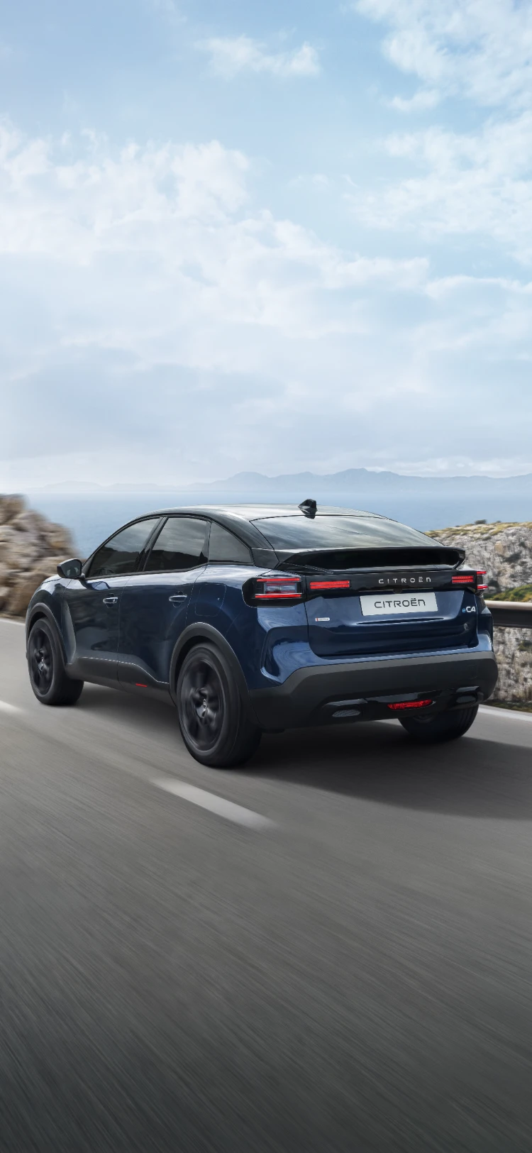 Vue de trois-quarts arrière de la ë-C4en mouvement , mettant en avant le design aérodynamique du crossover, l'efficacité et le style pour une présence moderne haut de gamme