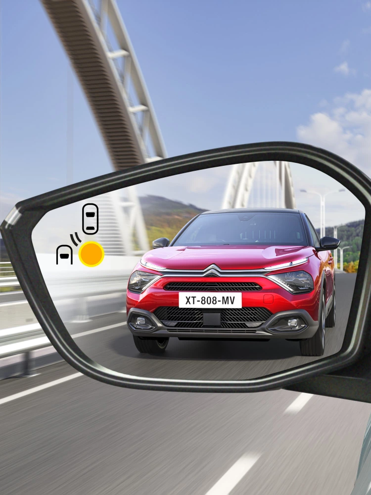 Alerte de détection d'angle mort dans le rétroviseur de la Citroën C4 X indiquant un véhicule s'approchant par l'arrière