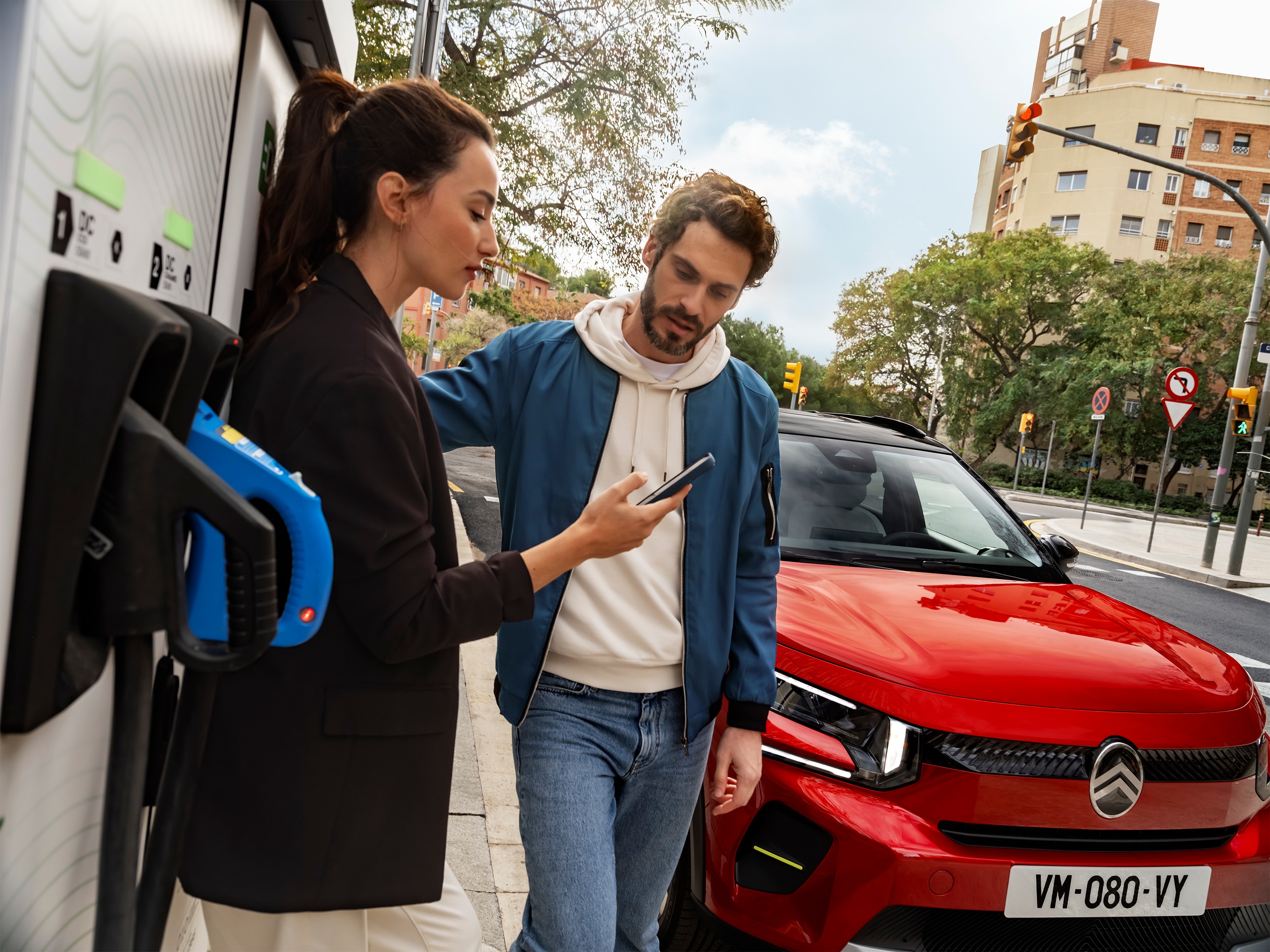 Vue Citroën C3 SUV en charge dans la rue, avec des personnes préparant une recharge rapide pour une mobilité efficace.