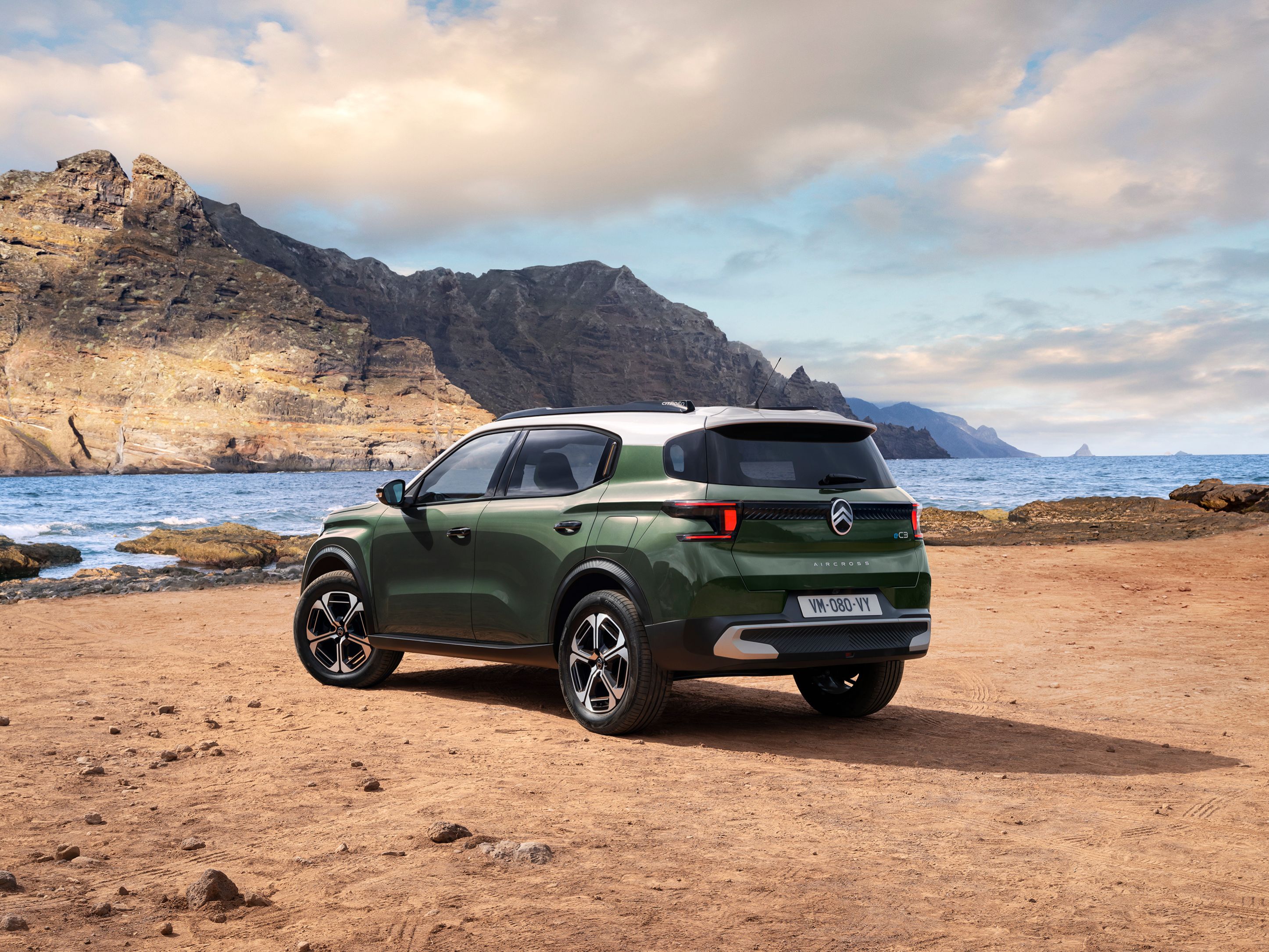 Vue 3/4 arrière de Citroën ë-C3 Aircross au bord mer, son design de SUV pour une mobilité polyvalente, abordable.