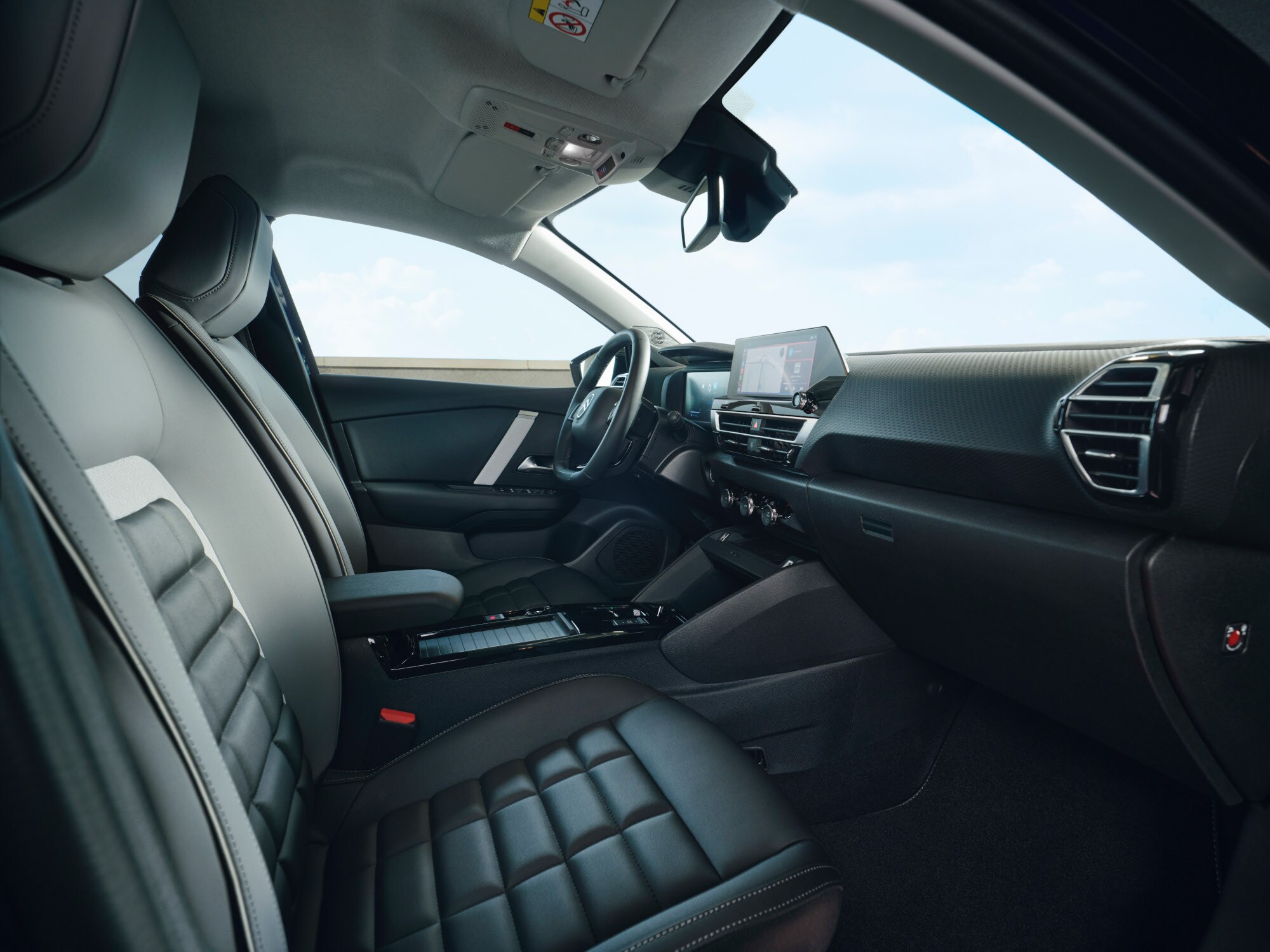 Vue intérieure avant de la Citroën C4 X montrant les sièges, le tableau de bord et l'écran central