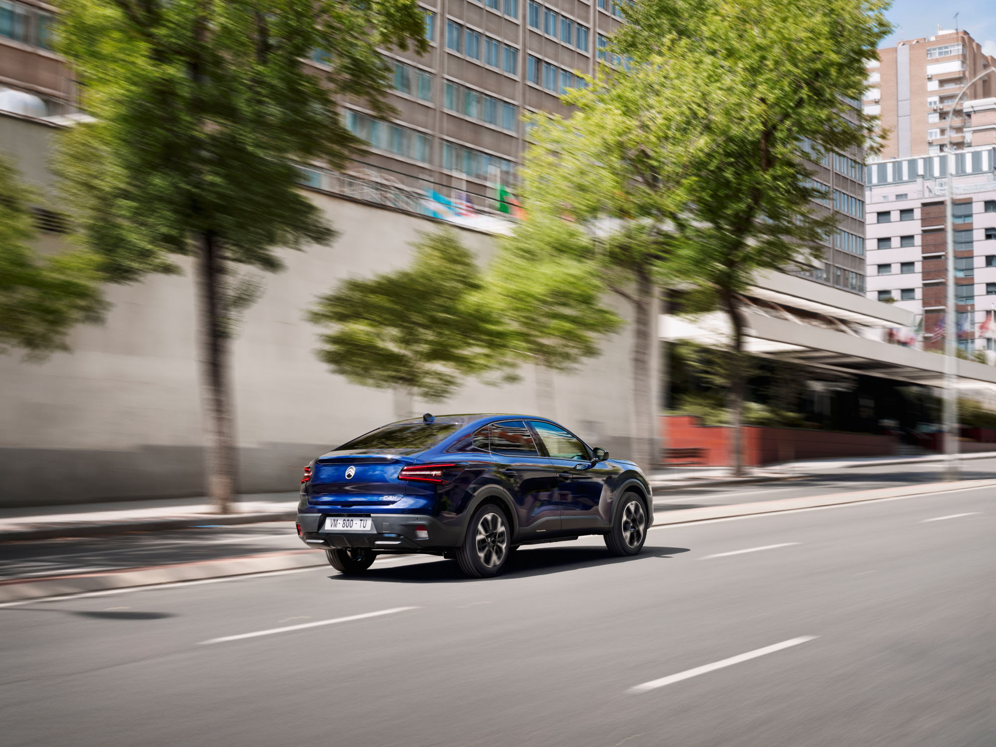 Vue 3/4 arrière de la Citroën C4 X en mouvement, avec son style fastback mobilité abordable