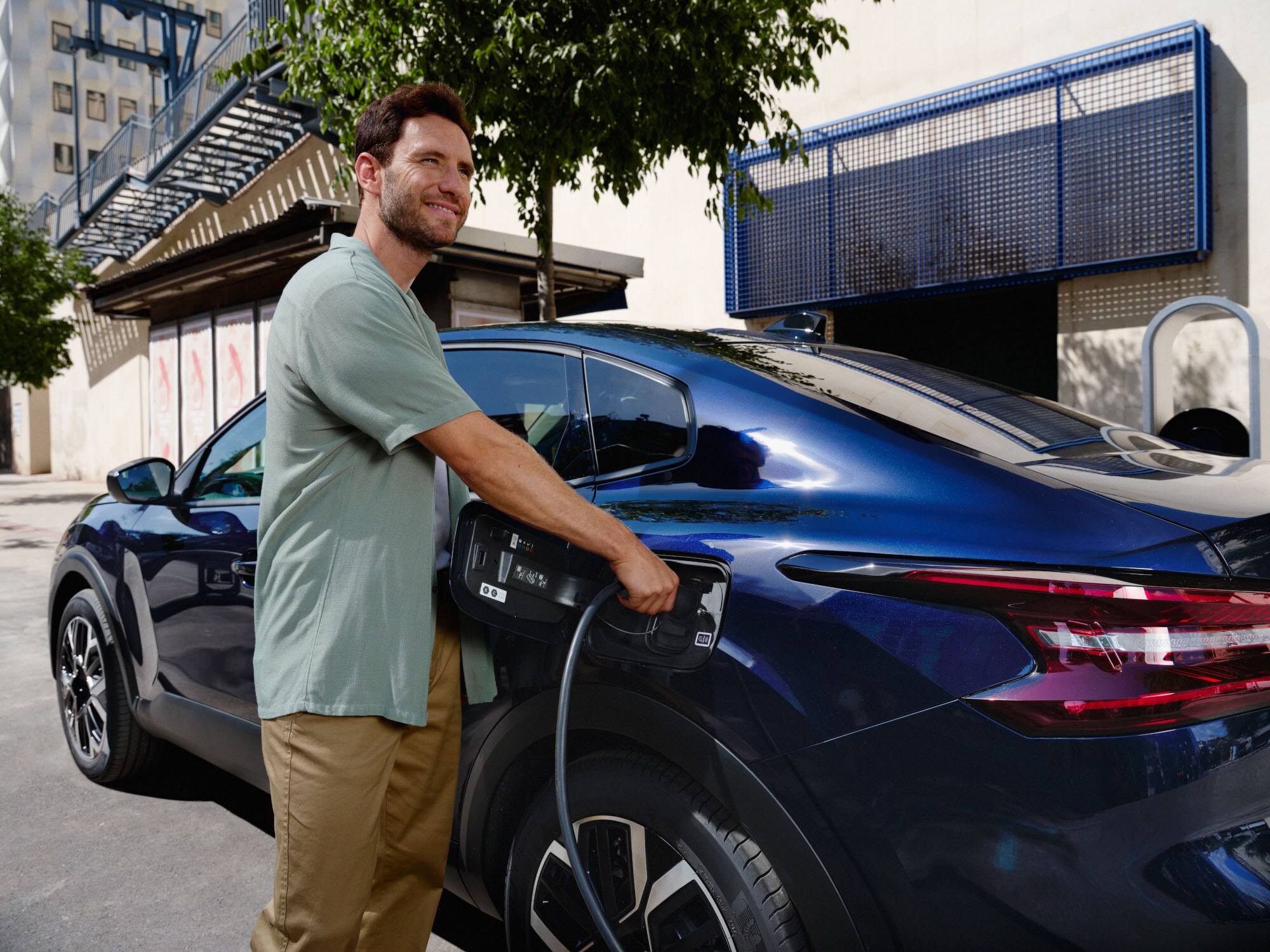 Vue de la Citroën C4 X fastback en cours de recharge, illustrant la facilité d'accès à la prise.